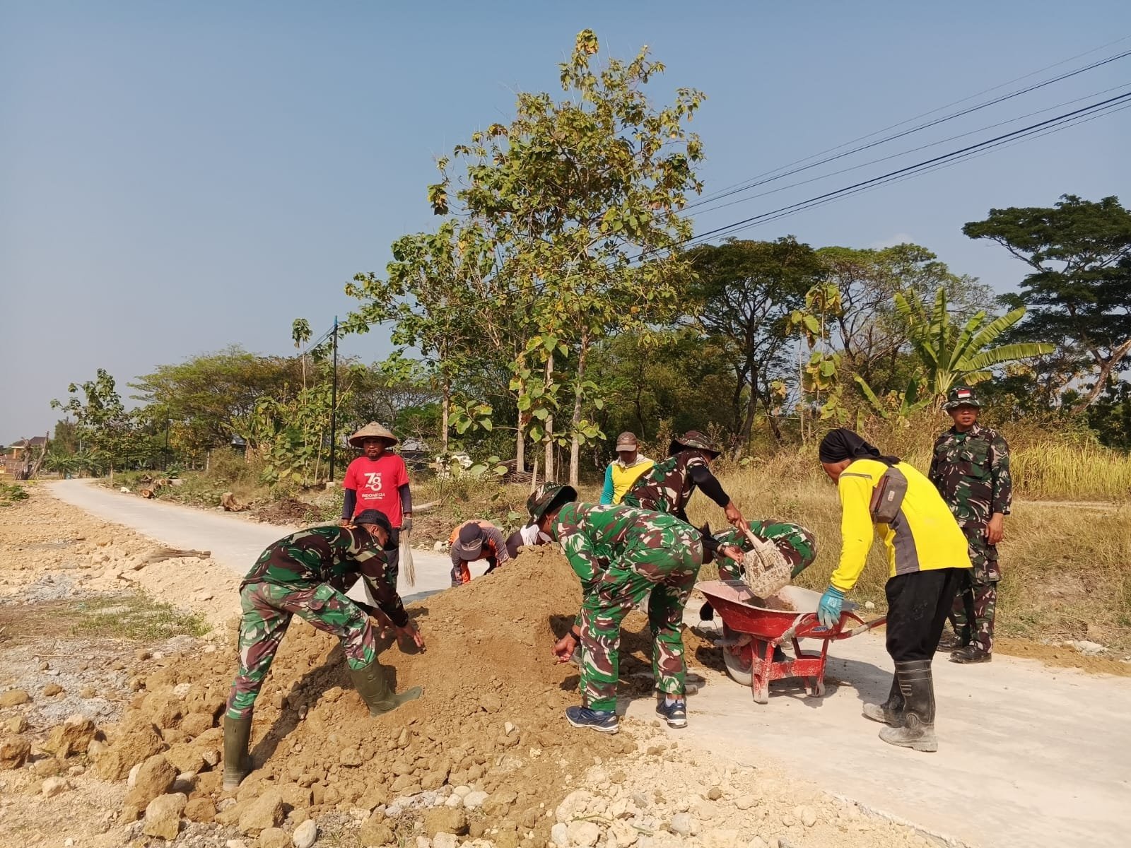 Warga dan Satgas TMMD Rapihkan Bahu Jalan Parangjoro untuk Lindungi Cor
