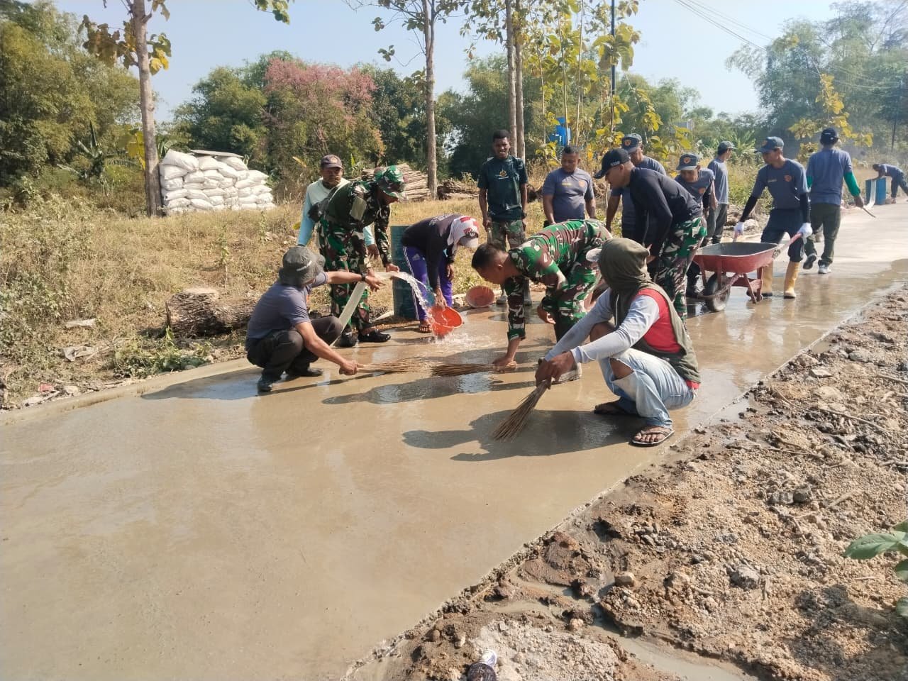 Warga dan Satgas TMMD Rapihkan Pekerjaan Jalan Beton Parangjoro
